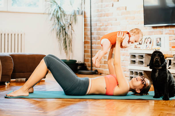 istock Woman exercising at home with baby 1281594157
