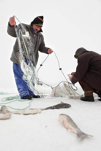 Lake Çıldır is frozen every winter. In the cold season all fishermen from around villages of the lake are fishing on the lake by opening a hole on ice. These images have been captured while the temperature is -25 centigrade. Lake is in Kars, Turkey.