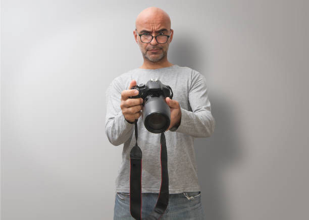 istock Attractive dark-haired bald man with three-day beard, gesturing and  glad to take good photos 1281594696