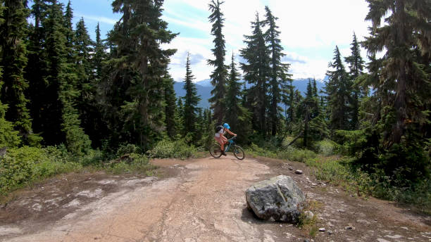 istock Female mountain biker rides up alpine trail 1281594750