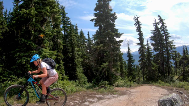 istock Female mountain biker rides up alpine trail 1281594778