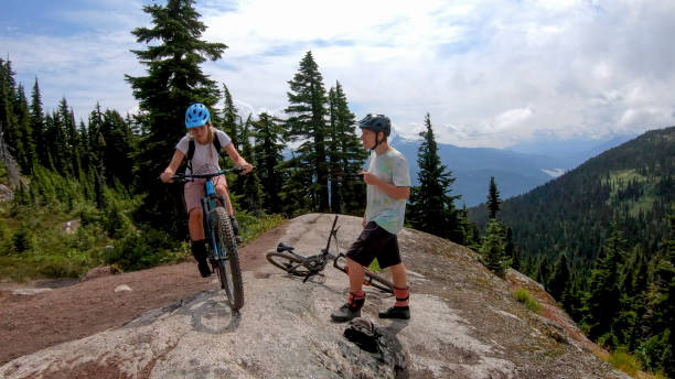 istock Mountain bikers ride along alpine trail 1281595350