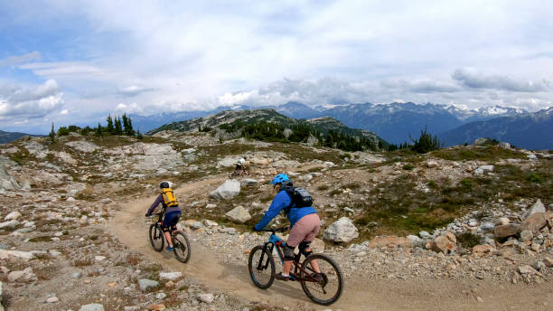istock Mountain bikers ride along alpine trail 1281595473