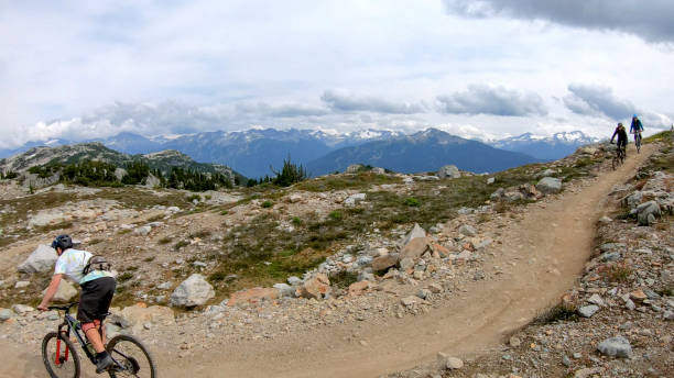 istock Mountain bikers ride along alpine trail 1281595488