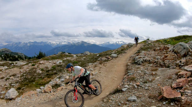istock Mountain bikers ride along alpine trail 1281595516