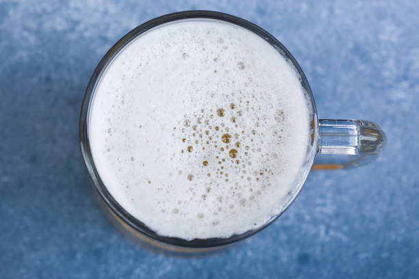 istock Beer in a glass on a blue background 1281595716