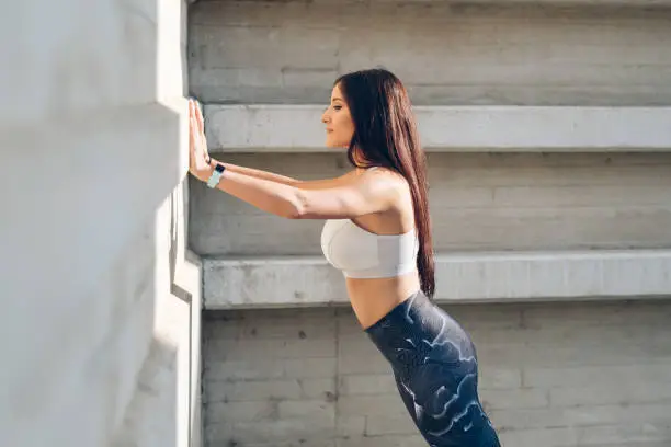 Photo of Fitness woman doing standing wall push-ups
