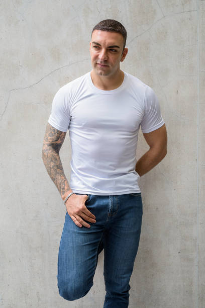 istock Handsome man with tattoos thinking and leaning against wall 1281596005