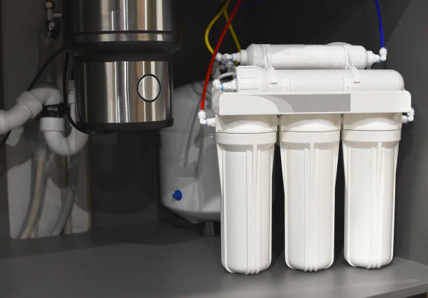 istock House water filtration system. Osmosis deionization system. Installation of water purification filters under kitchen sink in cupboard 1281596009