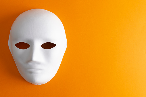 White mask on orange colored background.