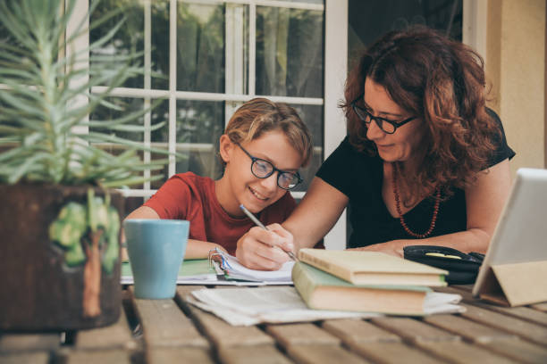 istock Mother Assisting Son In Homework At Home 1281601843