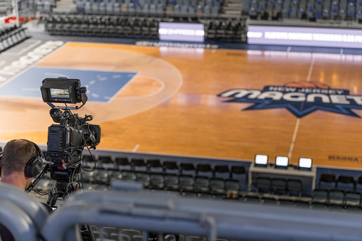 Rear view of cameraman shooting empty basketball court.