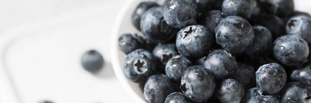 istock Blueberries in a white bowl on a light background. Banner 1281602542
