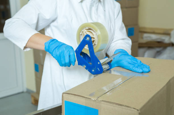 istock Women's hands seal the box with adhesive tape. 1281603488