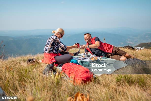 Adult Couple Having Picnic In Mountains Stock Photo - Download Image Now - Picnic, Mature Couple, Hiking