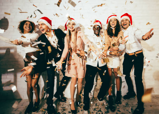 istock Men And Women Celebrating Christmas Standing Under Falling Confetti Indoor 1281607437