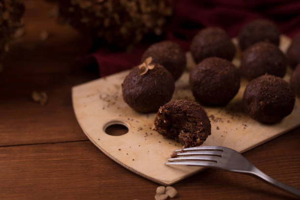 istock Cocoa balls, chocolate truffles cakes on board on wooden background 1281609227
