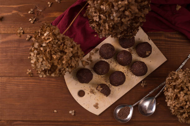 istock Cocoa balls, chocolate truffles cakes on board on wooden background 1281609242