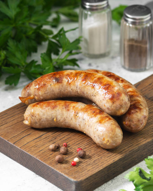 istock Grilled sausages on a wooden Board on a light gray kitchen table 1281609447