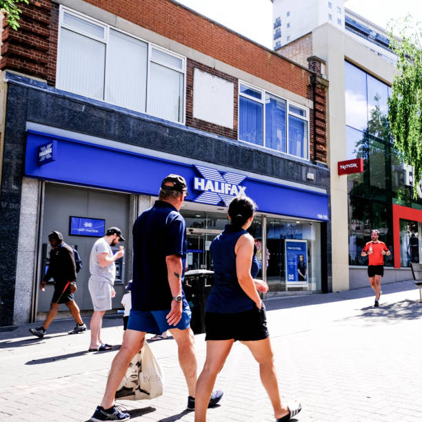 gruppo di persone che camminano oltre un ramo di high street della nationwide building society durante il blocco covid-19 - nationwide foto e immagini stock