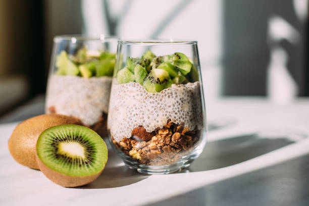 Healthy breakfast. chia pudding with kiwi and granola in glass Healthy breakfast. chia pudding with kiwi and granola in glass on white background chia seed stock pictures, royalty-free photos & images