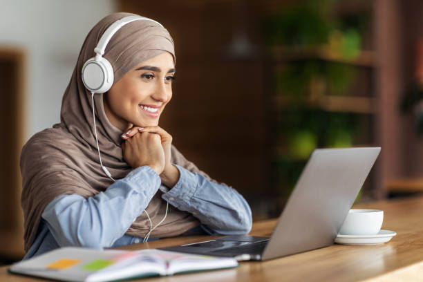 istock Happy female student having online lesson at cafe 1281613897