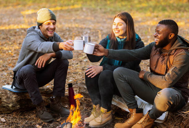 istock Cheerful hikers toasting for nice camping in sunset lights 1281614278