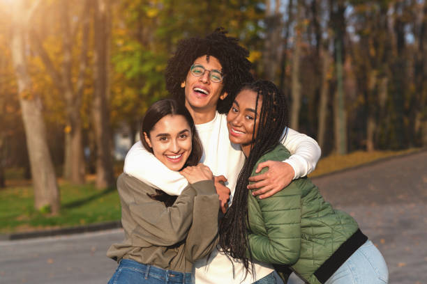 istock Cheerful african guy hugging his smiling girlfriends 1281615532