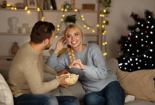 istock Joyful man and woman spending time at home, eating popcorn 1281615559