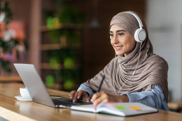 istock Smiling muslim lady studying online at cafe 1281616293