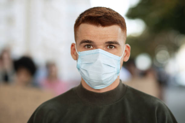 istock Guy in face mask over group of demonstrators 1281616368