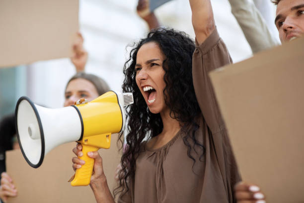 istock Active woman with megaphone attending public meeting 1281616460