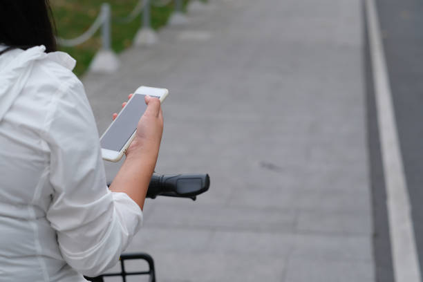 istock woman using phone while sitting on bike 1281618810