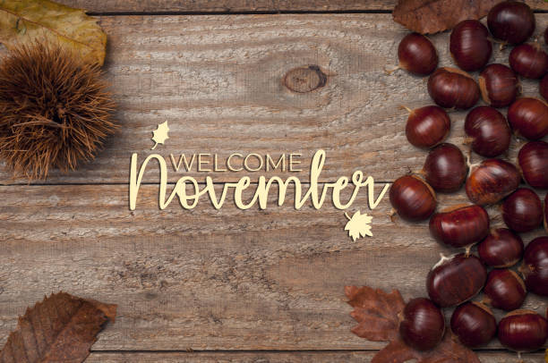 istock Welcome November card. Roasted chestnuts on a wooden table with some leaf and a hedgehog. 1281618936