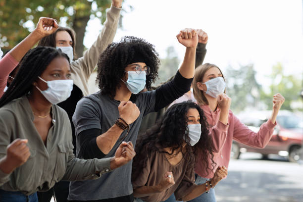 istock Young people in protective masks attending demonstration on the street 1281621817