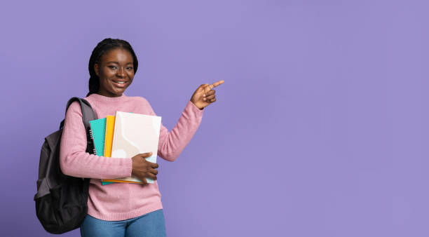 istock Young black female student pointing aside at copy space with finger 1281622125
