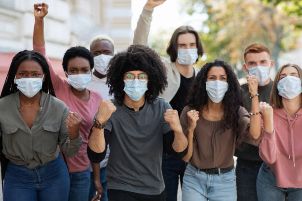 istock People wearing protective face mask protesting and showing fists 1281622469