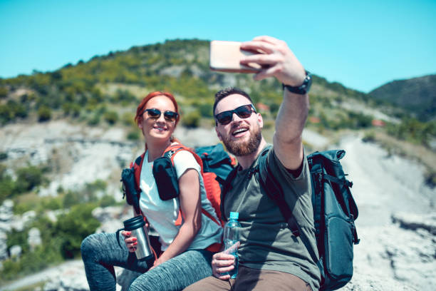 istock Cute Couple Taking Selfie While Hiking Rocks 1281623566