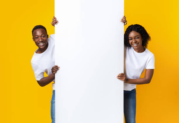 istock Cheerful african couple holding empty board for advertisement 1281623763