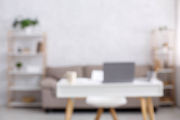 istock Home office, workspace for remote work. Sofa, chair and table with laptop and cup in interior of living room during COVID-19 pandemic 1281623792