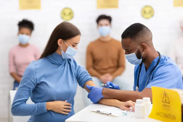 Photo of Doctor Making Coronavirus Vaccine Injection To Pregnant Woman In Hospital