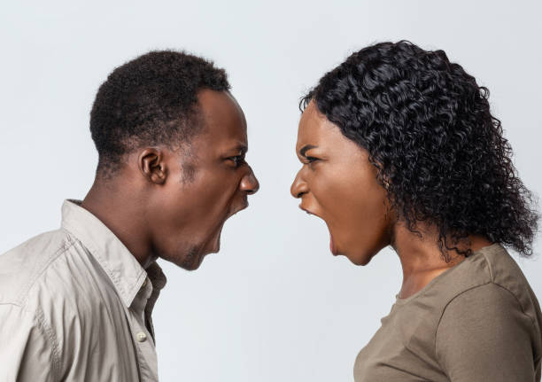 istock Black man and woman fighting over grey background 1281623887
