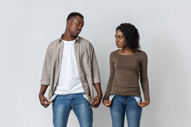 istock Black Man And Woman With Empty Pockets Over Grey 1281624071