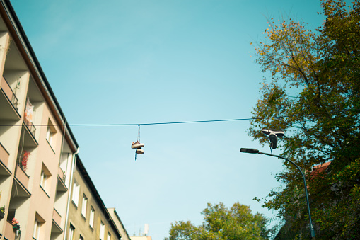 Youth shoes hang on high voltage wire. Krakow in Poland. No people.