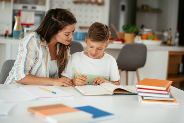 istock Mother helping her son with homework at home. 1281626116