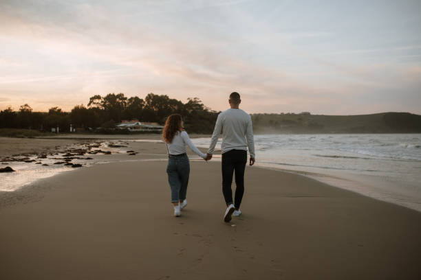 istock Rear view of a young couple holding hands 1281627671