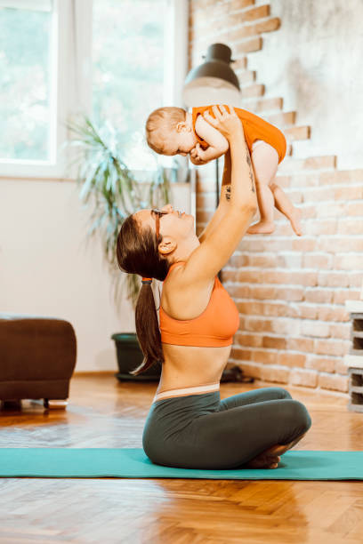 istock Woman exercising at home with baby 1281627756