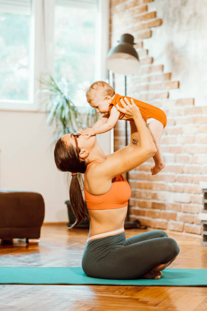 istock Woman exercising at home with baby 1281627806