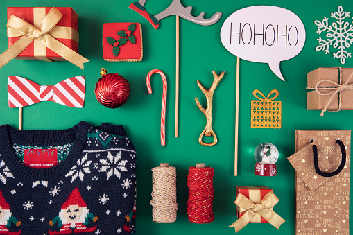 Christmas related objects and ornaments  flat lay on green background