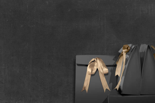 istock Paper bag with gold ribbon with black wall background 1281631692